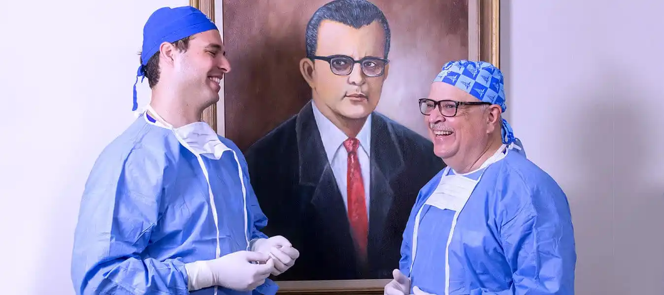 Tres generaciones de oftalmólogos de Centro Láser, frente al retrato del fundador Dr. Oscar R. Batlle Morel
